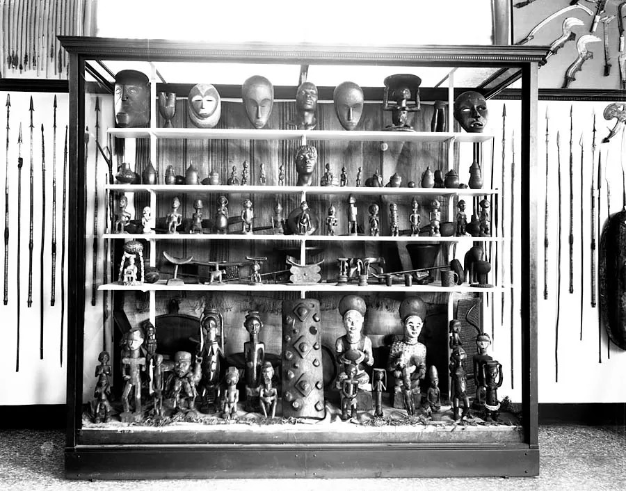 A case with carved figures. Ward exhibition (c. 1922), . Two of Ward's bronze studies, Mask of the Negro Man and Mask of the Negro Woman, were installed in this case alongside Congolese figures and masks.